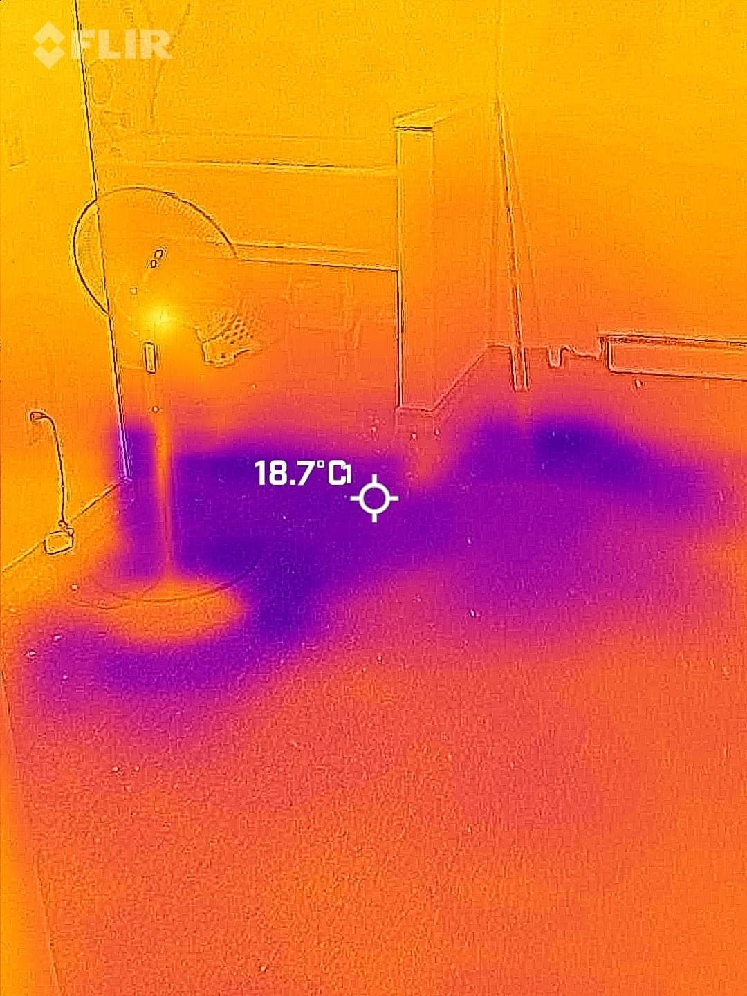 Thermal camera image showing cold purple wet areas spreading across a floor during moisture inspection